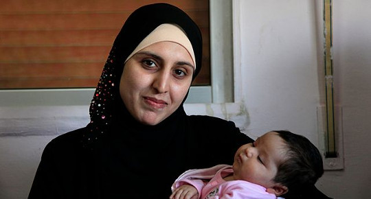 A Syrian refugee woman with her 25-day-old daughter